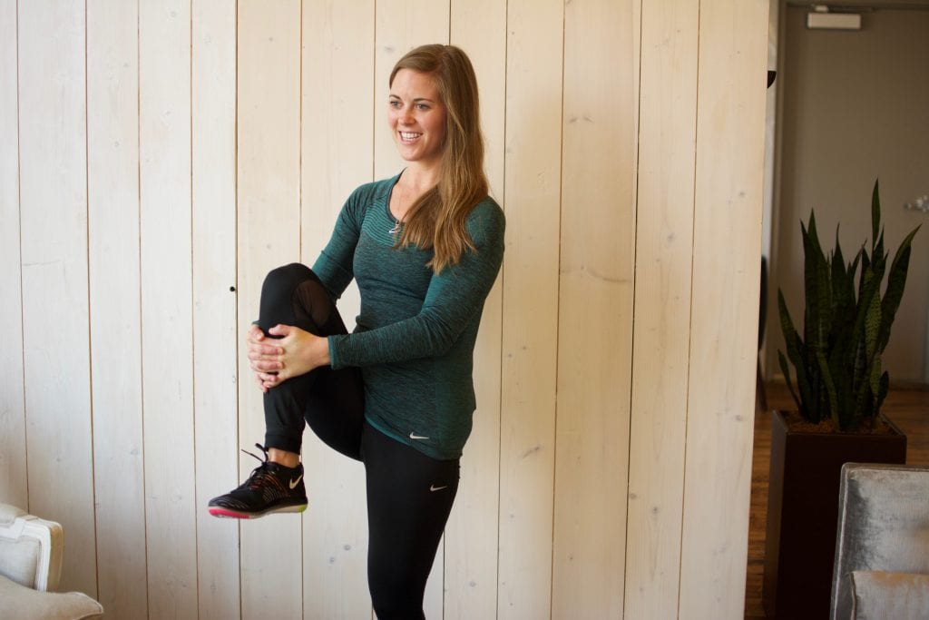 Stretching in Nike Dri-Fit long sleeved running top, Nike Epic Run mesh insert running tights, and Nike Free Transform Flyknit training shoes