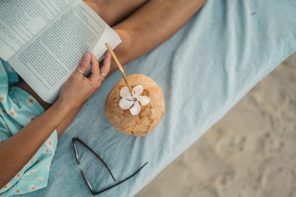 person reading wellness book on the beach