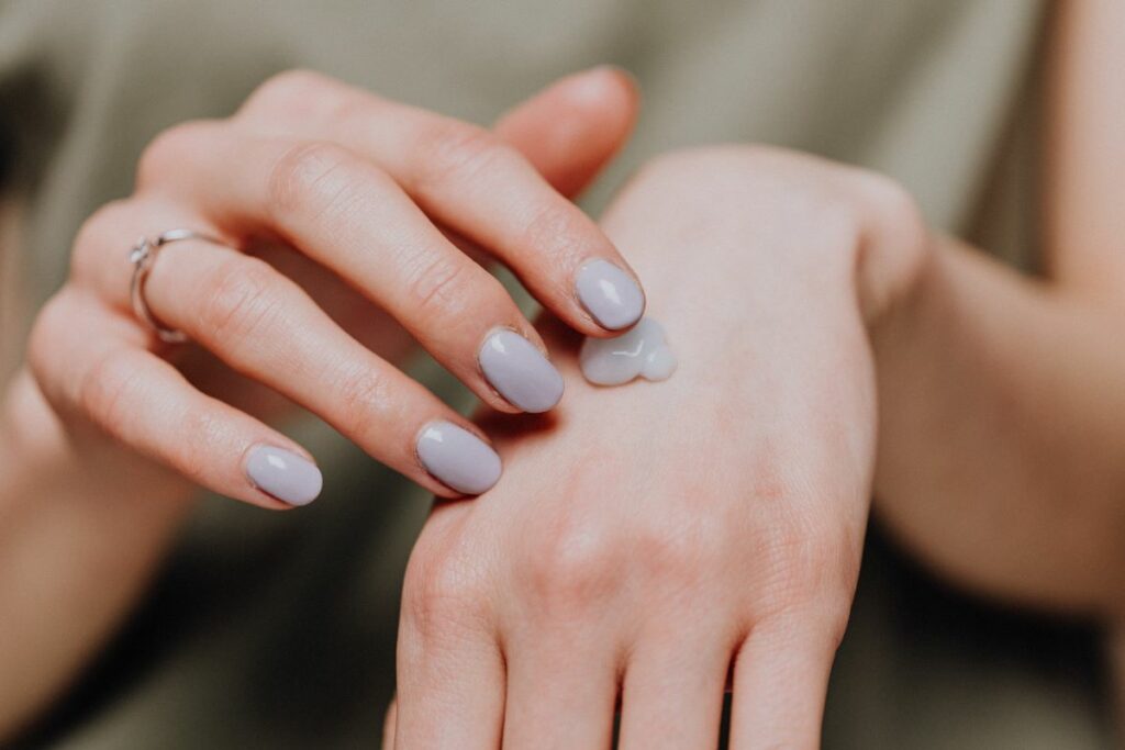 person applying moisturizer on hand