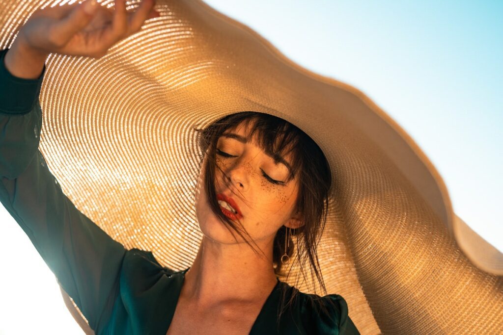 woman with freckles wearing wide brimmed hat