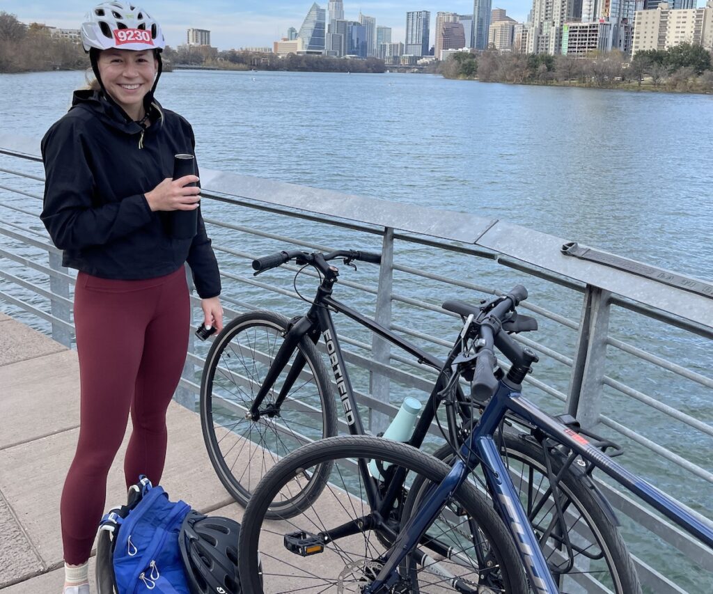 person smiling next to bicycle