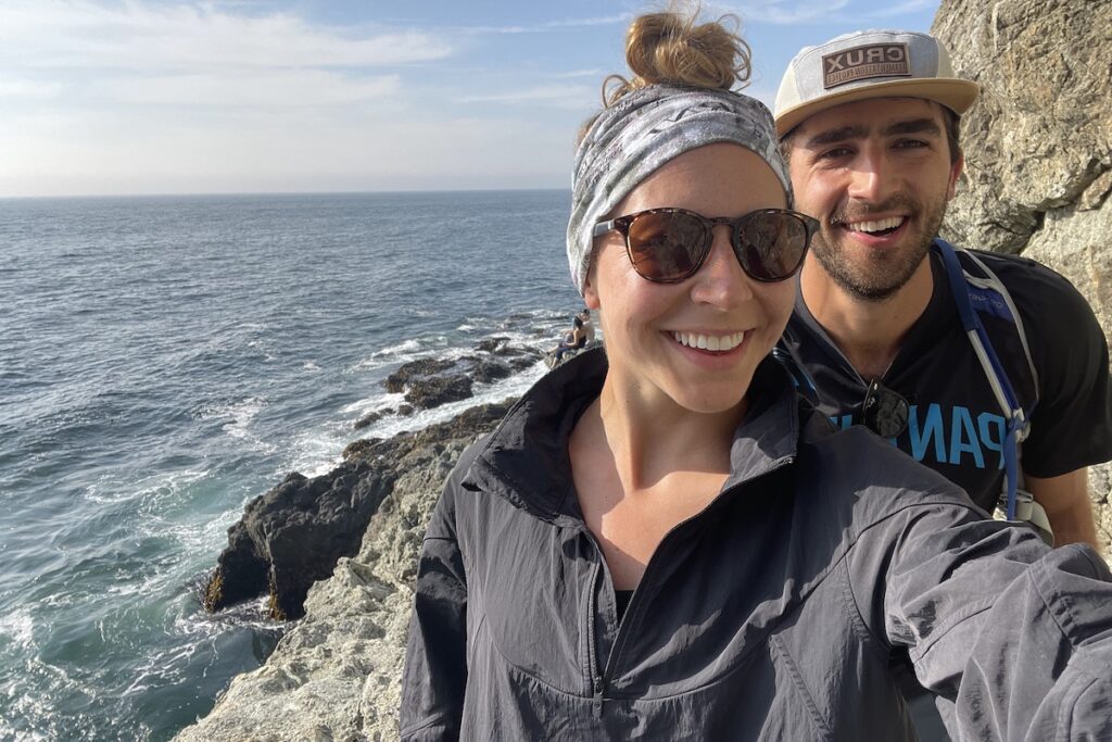 two people smiling by ocean