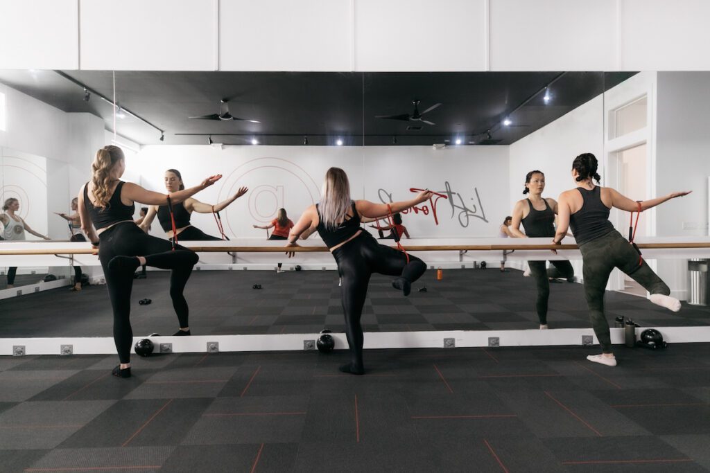 people working out barefoot in barre class