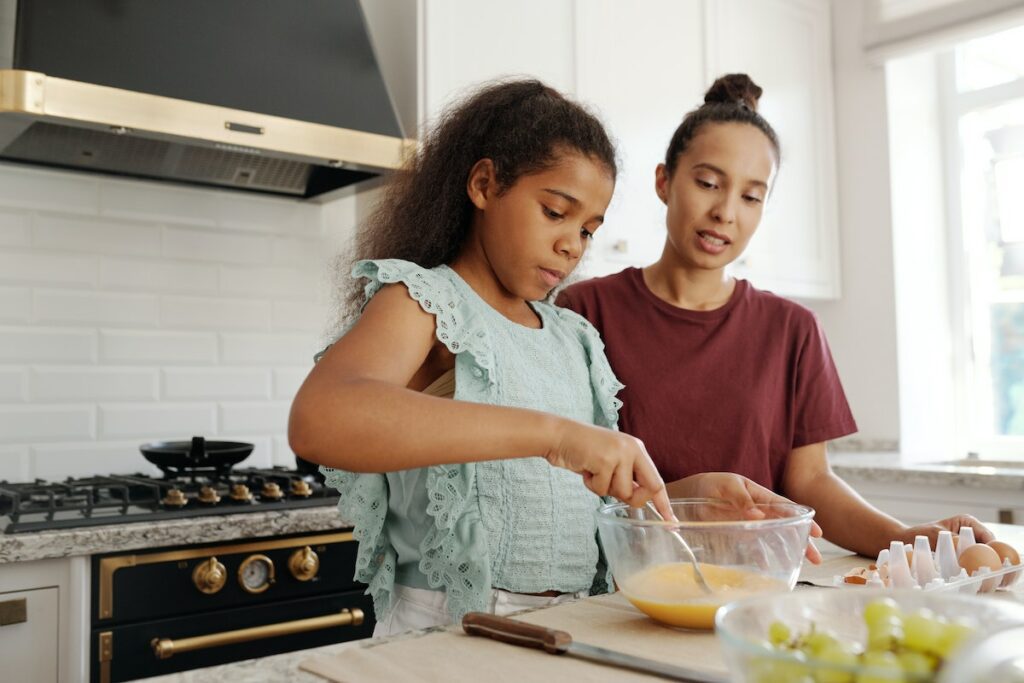 parent and child in kitchen cooking together