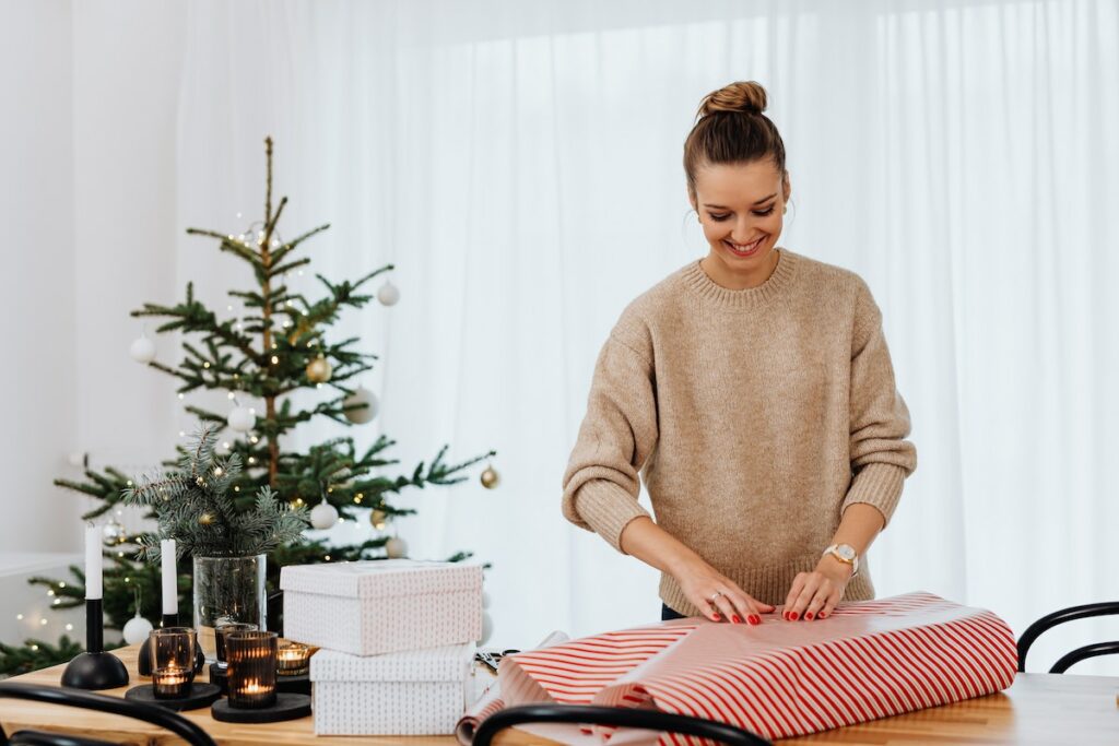 person wrapping present for holiday