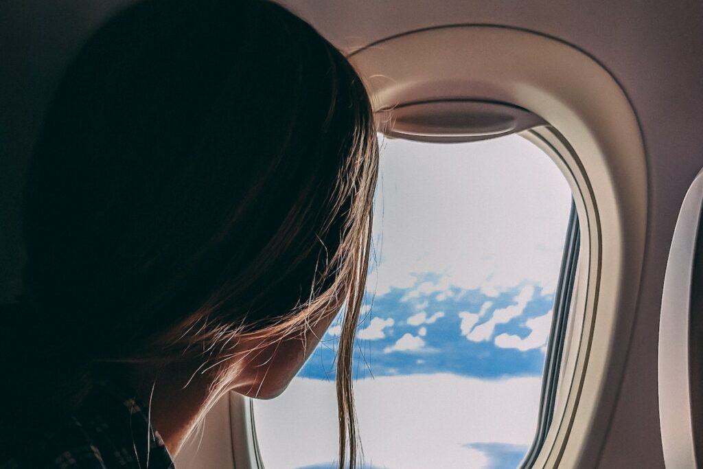 person looking out window in airplane