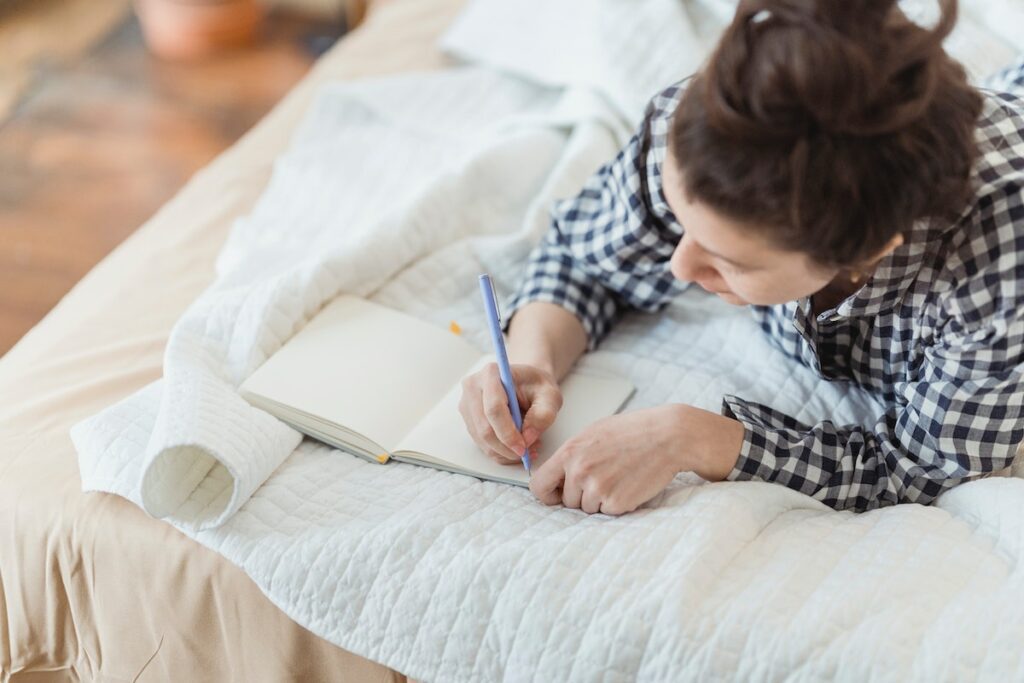 person writing in gratitude journal