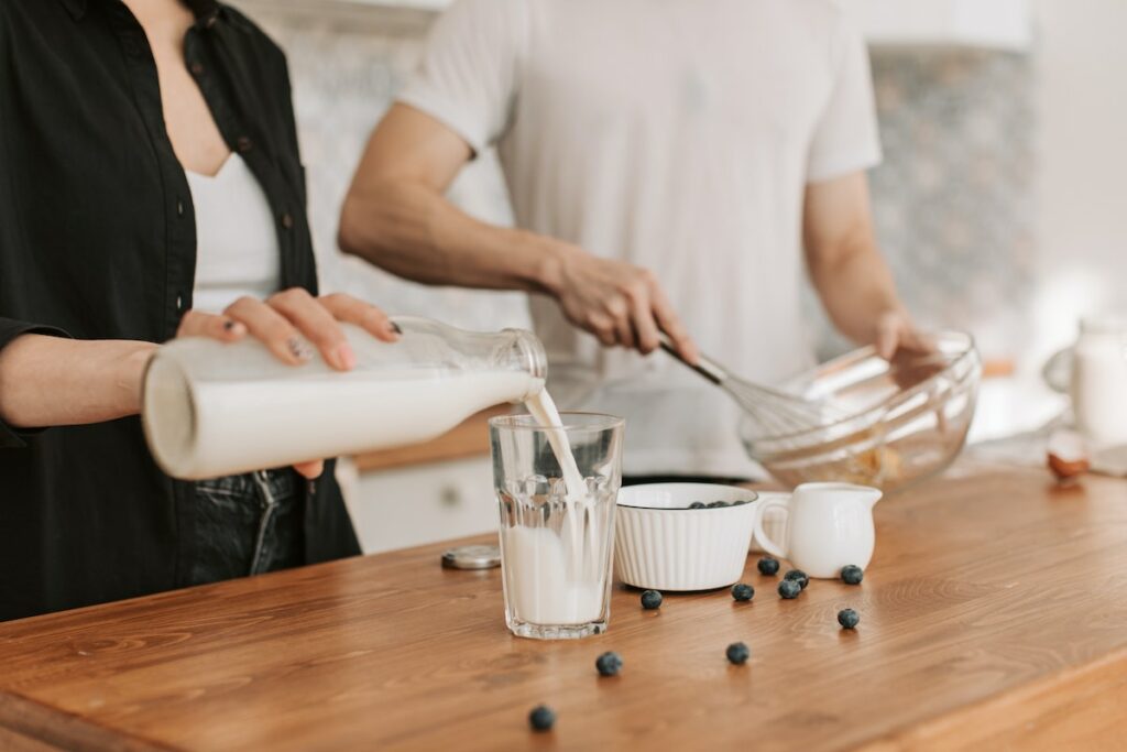 person using non-dominant hand to pour milk