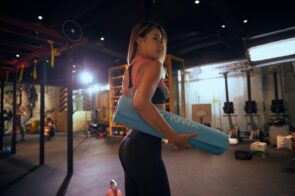 person holding yoga mat getting ready to work out